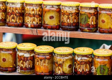 Süßer Honig mit Nüssen und Früchten in Gläsern Stockfoto