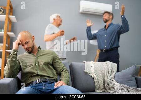 Großvater Mit Konflikt Mit Vater, Während Traurige Sohn Auf Der Couch Sitzen Stockfoto