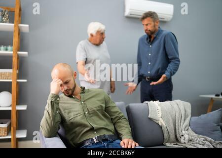 Großvater Mit Konflikt Mit Vater, Während Traurige Sohn Auf Der Couch Sitzen Stockfoto