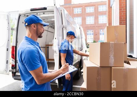 Van Courier Und Professional Movers Unload Truck Stockfoto