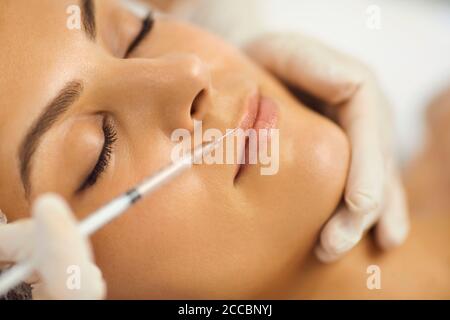 Hände von Kosmetologen Herstellung Botox Injektion in weibliche Oberlippe Mit Spritze Stockfoto