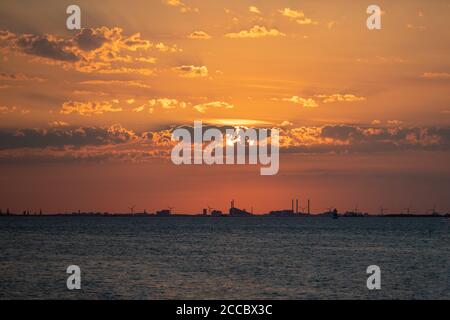 Ein atemberaubender orangefarbener Sonnenuntergang über dem Meer ein schöner Sommerabend in Malmö, Südschweden Stockfoto