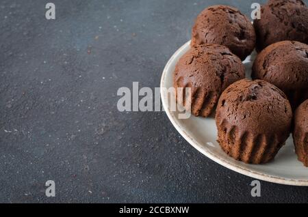 Teller voll mit Schokolade Muffins auf dunklem Hintergrund. Köstliches Schokoladendessert. Stockfoto