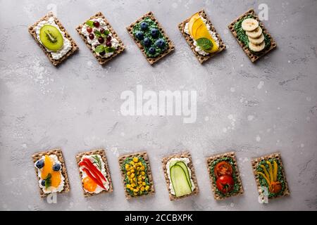 Sandwiches mit Gemüse, Obst, Beeren, Chlorella, Spirulina, Käse. Heidelbeere, Traube, Mais, Pfeffer, Banane, Mandarine, Tomate, Kiwi, Gurke, Stockfoto