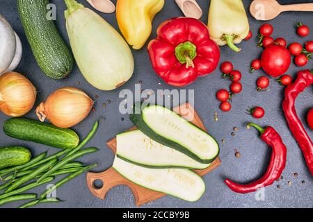 Gehackte dunkelgrüne Zucchini auf Holzbrett mit Gemüse flat Stockfoto
