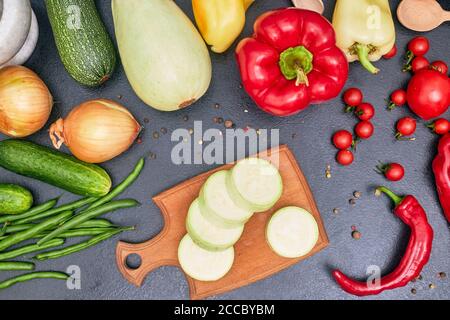 Gehackte hellgrüne Zucchini auf einem Holzbrett mit Gemüse Flatlay Stockfoto