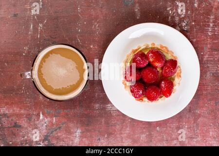 Erdbeer-Shortcake und Tasse Kaffee auf altem Holztisch. Stockfoto