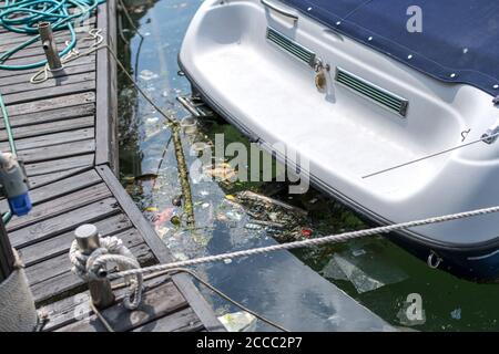 Ein ekelhafter Haufen Verschmutzung schwimmt im Meer unter dem Boot. Stockfoto