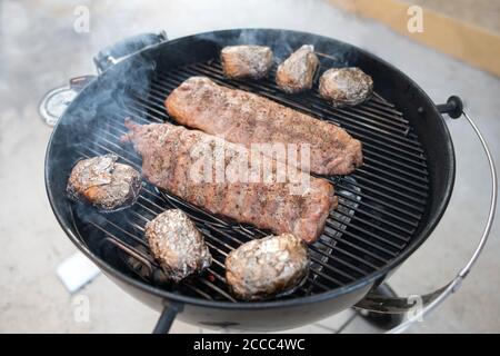 Schweineribs gebacken zu einem knackigen auf einem rauchigen Grill Stockfoto