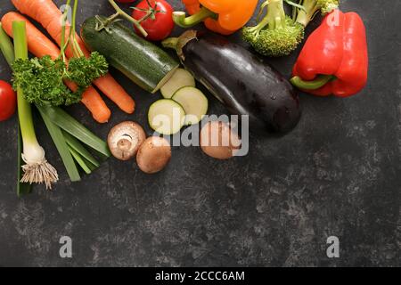 Buntes Bio-Gemüse auf dunkelgrauem Hintergrund mit Kopierraum, gesundes Esskonzept, Weitwinkel-Ansicht von oben Stockfoto