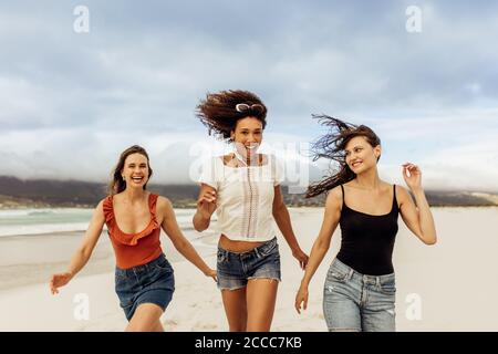 Drei fröhliche Freunde genießen am Strand. Multiethnische Freunde auf einem Urlaub Spaß am Strand. Stockfoto
