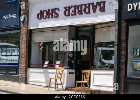 Winchester, Vereinigtes Königreich - 16. Juli 2020: Coiffeur Shop Friseur arbeitet während Pandemie Anwendung sozialer Distanzierung und PSA für Kunden und Crew Stockfoto