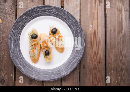 Blick von oben auf Lachs Sandwiches serviert als Tapas in einem Bar auf einem Holztisch Stockfoto