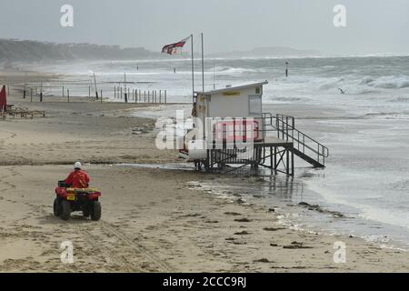 Sturm Ellen schlägt die Südküste von England auf dem Höhepunkt der Sommerferiensaison mit Windböen von bis zu 60 mph und einer Flut. Ein Rettungsschwimmer patrouilliert am Strand in einem Buggy, Boscombe, Bournemouth, Dorset, Großbritannien, 21. August 2020 Stockfoto