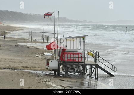 Sturm Ellen schlägt die Südküste von England auf dem Höhepunkt der Sommerferiensaison mit Windböen von bis zu 60 mph und einer Flut, EIN Rettungsschwimmer kämpft mit einer roten Gefahr Flagge Bling in den Wind, Boscombe, Bournemouth, Dorset, UK, 21. August 2020 Stockfoto