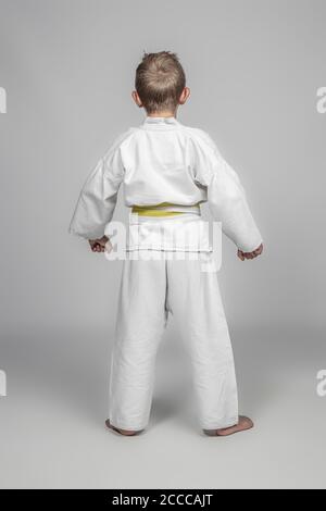 Porträt eines Kindes mit Kampfkunst Kimono stehend. Konzept des Sports für Kinder. Stockfoto