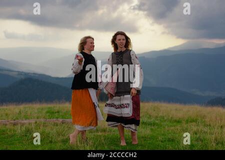 Zwei emotionale fröhliche Mädchen in ukrainischen Stickerei Kleidung hoch in Die karpaten im Sommer Stockfoto