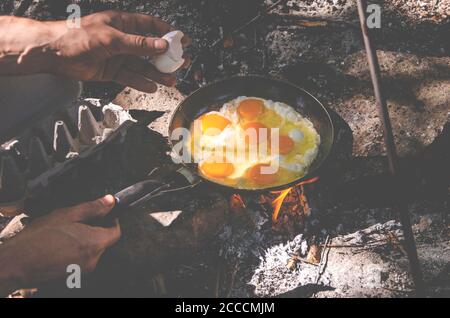 Ei von Männerhänden auf einem Feuer in der gekocht Hölzer Stockfoto