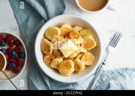 Pfannkuchen, Müsli, winzig dünne, lustige Krümel, Kinderessen. Frühstück mit Getränk Stockfoto