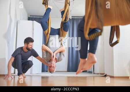 Fröhliche barfuß Anfänger Yogi hängend auf den Kopf Stockfoto