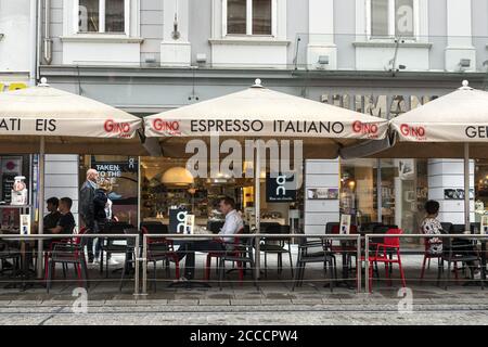 Graz, Österreich. August 2020. Einige Leute sitzen an den Tischen einer Bar in einer Straße im Stadtzentrum Stockfoto