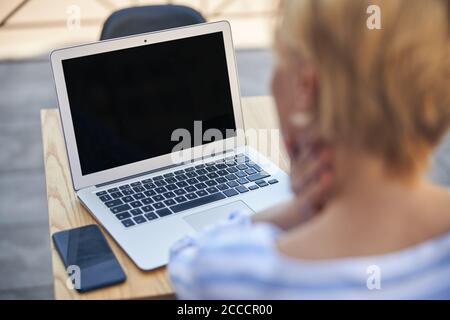 Blonde Frau an einem Computer in einem Café Stockfoto