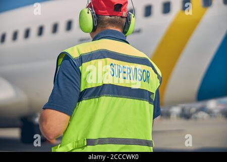 Mann in Arbeitskleidung, der ein Luftfahrzeug inspiziert Stockfoto