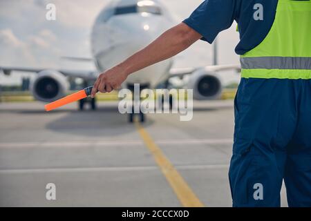 Erfahrener Flugzeugmarschall, der die Cockpit-Mannschaft signalisiert Stockfoto