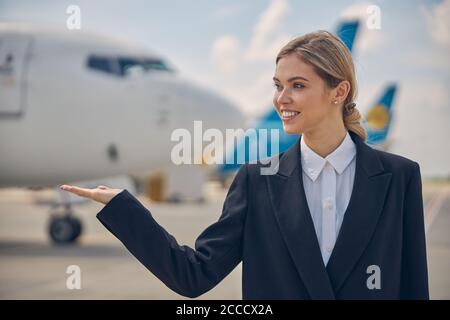 Ein sehr zufriedener Flughafenangestellter, der die Entfernung betrachtet Stockfoto