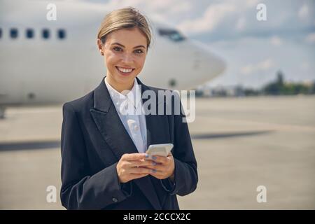 Fröhlicher Flughafenmitarbeiter, der für die Kamera posiert Stockfoto