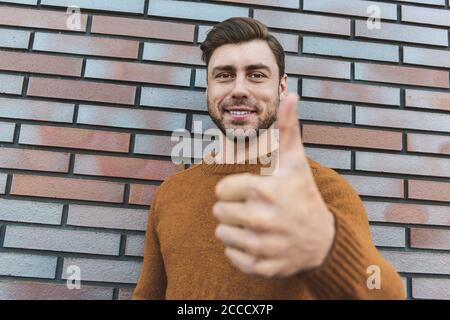 Nahaufnahme überrascht Mann in Brillen Blick auf Kamera und offenen Mund auf Backstein Hintergrund. Stockfoto