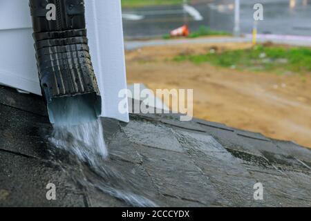 Die Arbeitsrinne an einem Regenwasser, das aus dem Wasser tropft, fließt während der Regenzeit auf das Dach. Stockfoto