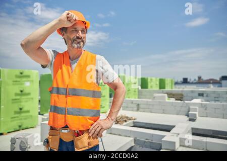 Männlicher Arbeiter in einem Schutzhelm, der draußen steht Stockfoto