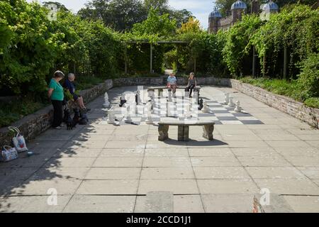 Eine Familiengruppe, die Schach im Freien in einem ummauerten Garten genießt, East Yorkshire, England, Großbritannien, GB. Stockfoto