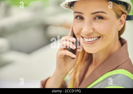 Ingenieurin mit einem Gadget, das die Kamera anlächelt Stockfoto