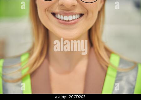 Fröhliche Arbeiterin in reflektierender Weste Stockfoto