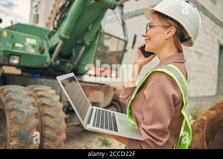 Zufrieden weibliche Auftragnehmer sprechen am Telefon Stockfoto