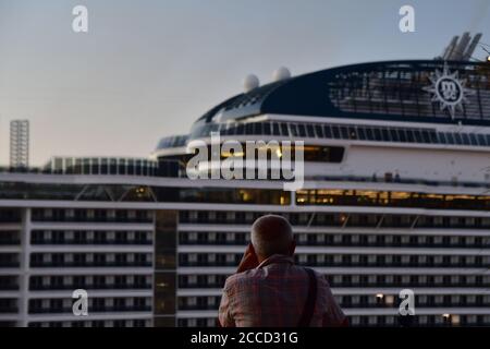 Valletta, Malta. August 2020. Ein Mann schaut auf das Kreuzfahrtschiff MSC Grandiosa im Hafen von Valletta, Malta, am 21. August 2020. Die MSC Grandiosa, ein Kreuzfahrtschiff der Meraviglia Plus-Klasse im Besitz und betrieben von MSC Cruises, fuhr am Freitagmorgen in den Hafen von Valletta und war damit der erste Kreuzfahrtschiff, der seit der Schließung der Häfen der Insel im März eintrifft, um die Ausbreitung des Coronavirus einzudämmen. Quelle: Jonathan Borg/Xinhua/Alamy Live News Stockfoto