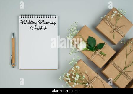 Schöne vintage flache Lay Komposition mit Holzfeder, Copybook und Geschenk oder präsentiert Boxen auf pastellgrauem Hintergrund mit Copyspace. Hochzeitsplanung Stockfoto