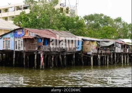 Hölzerne Slums auf Stelzen am Flussufer des Chao Phraya Fluss in Bangkok Stockfoto