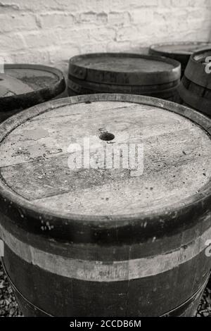 Alte Whisky-Fässer, die draußen in den Elementen verwittern, schwarz und weiß. Stockfoto