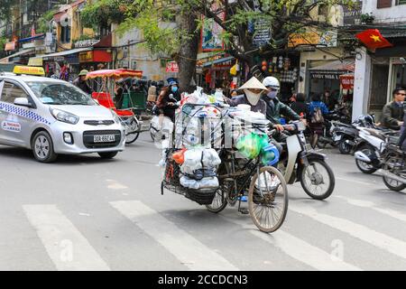Händler oder Straßenverkäufer verkaufen Haushaltswaren von Fahrrädern auf einer belebten Straße in Hanoi, Vietnam, Südostasien Stockfoto