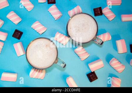 Heiße Weihnachten trinken Kakao Kaffee oder Schokolade mit Milch und Marshmallows Stücke Schokolade kleine transparente Tasse auf einem blauen Hintergrund Stockfoto