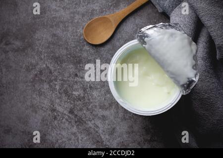 Joghurt in Plastikbecher auf dem Tisch Stockfoto