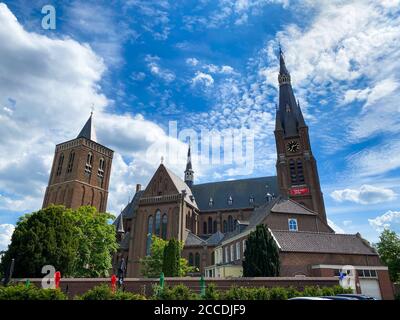 Cuijk, Niederlande - 9. August. 2020: Blick über den Garten auf die monumentale gotische Kirche gegen blauen Himmel im Sommer Stockfoto