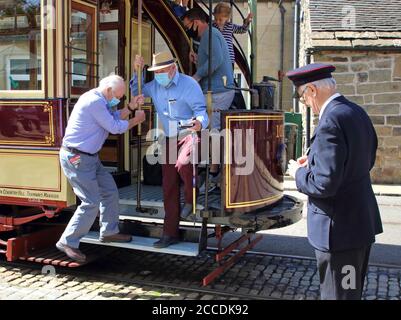 Derbyshire, Usa. August 2020. Passagiere steigen in der Straßenbahn aus, während sie Gesichtsmasken tragen, um die Ausbreitung des Coronavirus zu verhüten (COVID-19).in Großbritannien wurden die Museen mit Gesichtsschutzmasken wiedereröffnet, die in Innenräumen erforderlich sind. Mit Gesichtsmasken, die bereits im öffentlichen Verkehr vorgeschrieben sind, erforderte das Fahren auf einer der Oldtimer-Straßenbahnen im National Tramway Museum in Crich Tramway Village Gesichtsbedeckungen sowohl von Fahrgästen als auch von Fahrern. Kredit: SOPA Images Limited/Alamy Live Nachrichten Stockfoto