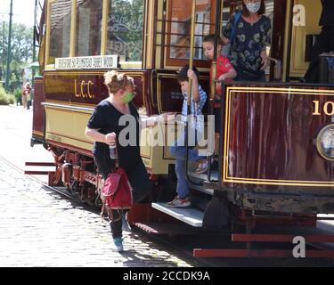 Derbyshire, Usa. August 2020. Passagiere steigen in der Straßenbahn aus, während sie Gesichtsmasken tragen, um die Ausbreitung des Coronavirus zu verhüten (COVID-19).in Großbritannien wurden die Museen mit Gesichtsschutzmasken wiedereröffnet, die in Innenräumen erforderlich sind. Mit Gesichtsmasken, die bereits im öffentlichen Verkehr vorgeschrieben sind, erforderte das Fahren auf einer der Oldtimer-Straßenbahnen im National Tramway Museum in Crich Tramway Village Gesichtsbedeckungen sowohl von Fahrgästen als auch von Fahrern. Kredit: SOPA Images Limited/Alamy Live Nachrichten Stockfoto