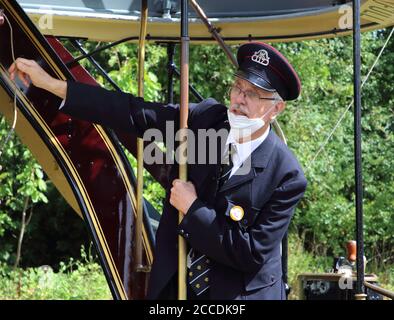 Derbyshire, Usa. August 2020. Ein Straßenbahnleiter läutet eine Glocke und kündigt an, dass es Zeit ist, abzureisen.Museen in Großbritannien wieder eröffnet mit schützenden Gesichtsmasken im Innenbereich erforderlich. Mit Gesichtsmasken, die bereits im öffentlichen Verkehr vorgeschrieben sind, erforderte das Fahren auf einer der Oldtimer-Straßenbahnen im National Tramway Museum in Crich Tramway Village Gesichtsbedeckungen sowohl von Fahrgästen als auch von Fahrern. Kredit: SOPA Images Limited/Alamy Live Nachrichten Stockfoto