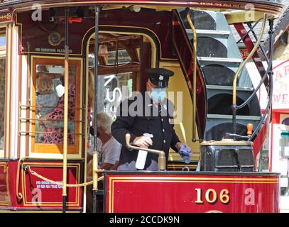 Derbyshire, Usa. August 2020. Ein Fahrer reinigt eine Straßenbahn, während er auf Passagiere wartet.Museen in Großbritannien mit Schutzmasken im Innenbereich wieder eröffnet. Mit Gesichtsmasken, die bereits im öffentlichen Verkehr vorgeschrieben sind, erforderte das Fahren auf einer der Oldtimer-Straßenbahnen im National Tramway Museum in Crich Tramway Village Gesichtsbedeckungen sowohl von Fahrgästen als auch von Fahrern. Kredit: SOPA Images Limited/Alamy Live Nachrichten Stockfoto