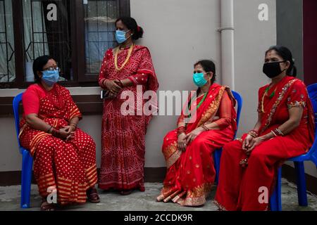 Kathmandu, Nepal. August 2020. Nepalesische Hindu-Frauen in traditionellen Kostümen und mit Gesichtsmasken als vorbeugende Maßnahme während des Teej-Festivals inmitten der Coronavirus-Krise (COVID-19).während dieses Festivals beobachten Hindu-Frauen ein ganztägiges Fasten und beten für ihre Ehemänner und für ein glückliches Eheleben. Diejenigen, die unverheiratet sind, beten für einen guten Mann. Kredit: SOPA Images Limited/Alamy Live Nachrichten Stockfoto